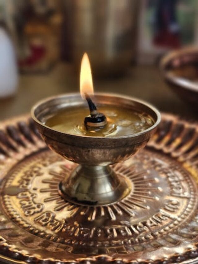 free-photo-of-a-small-candle-is-lit-on-a-metal-plate